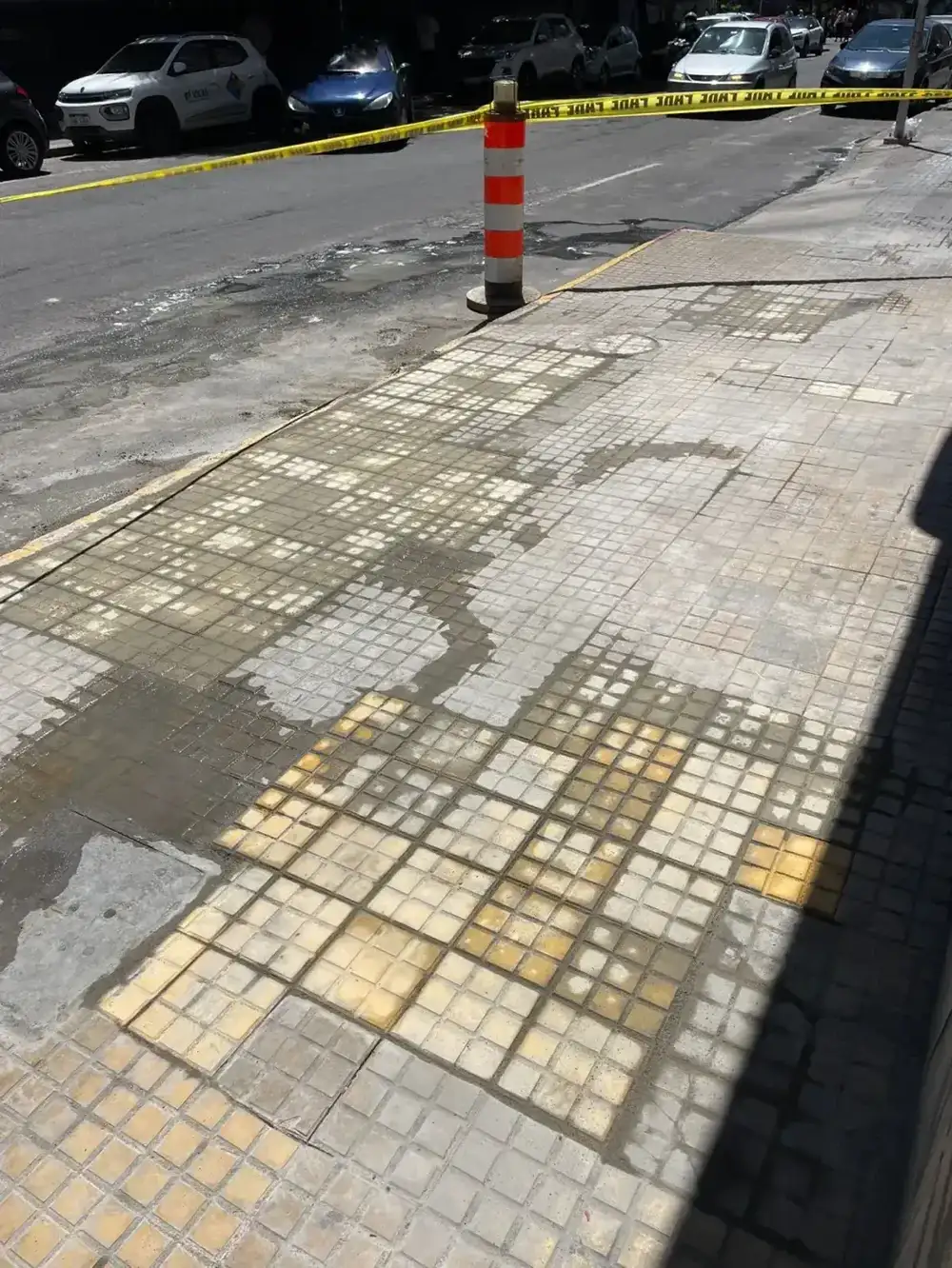 Baldosas recién colocadas en proceso de fragüe en la vereda