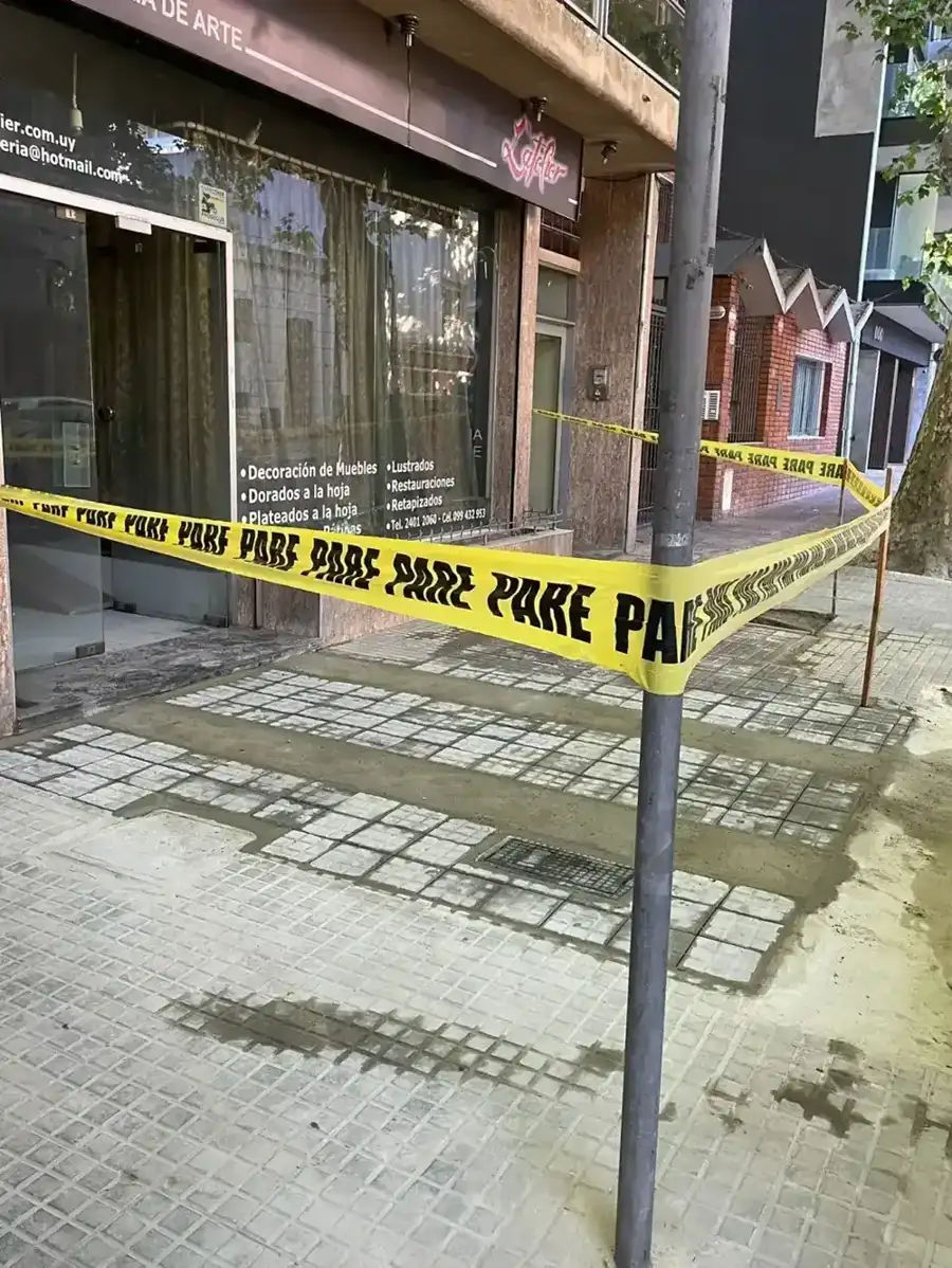 Tramo de vereda terminado y señalizado con cinta de obra frente a un local